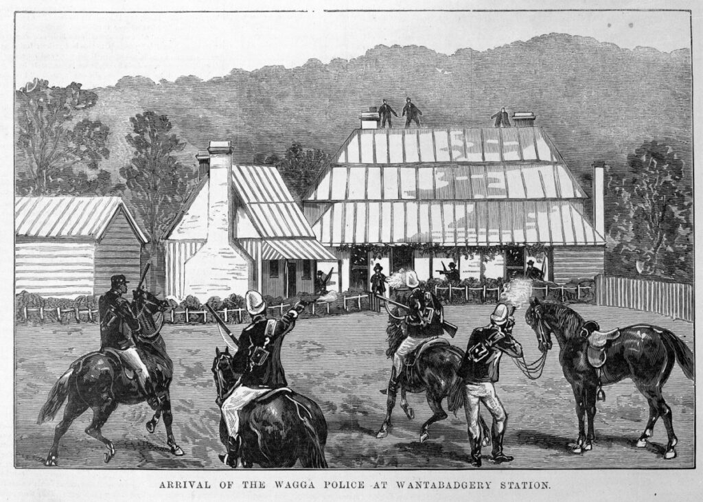 A black and white illustration of the arrival of mounted policemen to confront the Wantabadgery Bushrangers who have taken over Wantavbagery station. In the forefront four horses (three mounted) face away from the viewer. The unmounted policeman is firing his rifle to the station where three people can be seen on the rooftop.