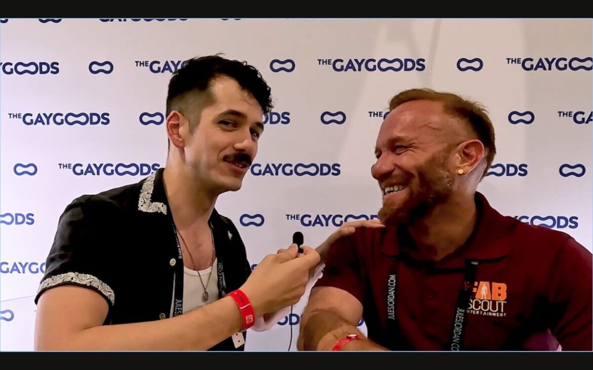 Screen Shot 2024 05 06 At 12.45.21 Pm Jonah Wheeler, a moustached dark haired man of approximately mid-30s is holding a lapel microphone in his right hand. With his left hand he has his shoulder on Steven Ponce, a redheaded muscular man in his early 40s. Steven is smiling widely at Jonah, who is looking side on at the viewer with a twinkle in his eye.